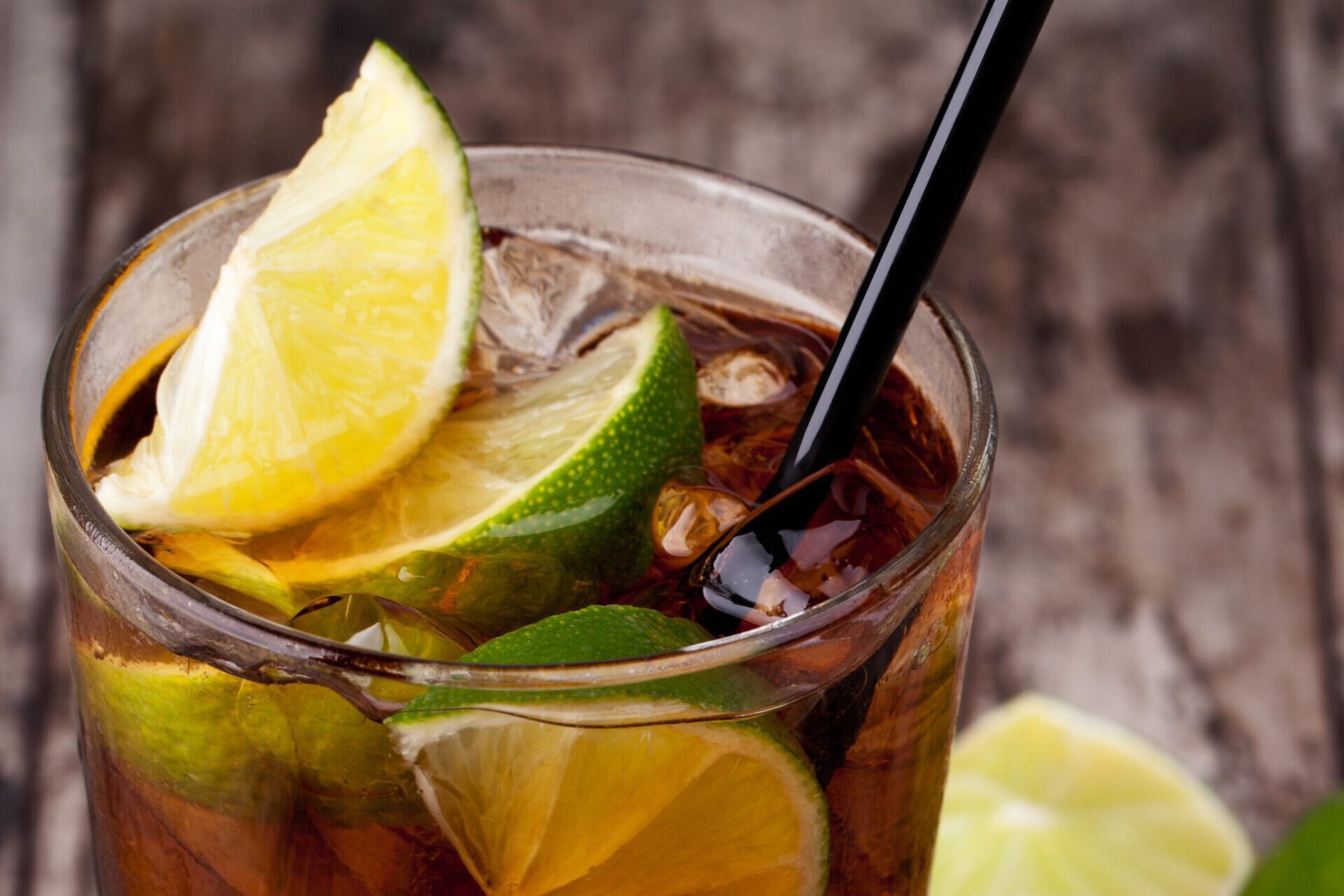 Cuba Libre Drink with lime on a wooden table